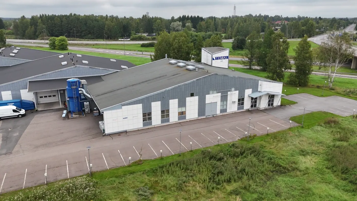 Ilmakuva teollisuuskiinteistön julkisivusta ja pysäköintialueesta